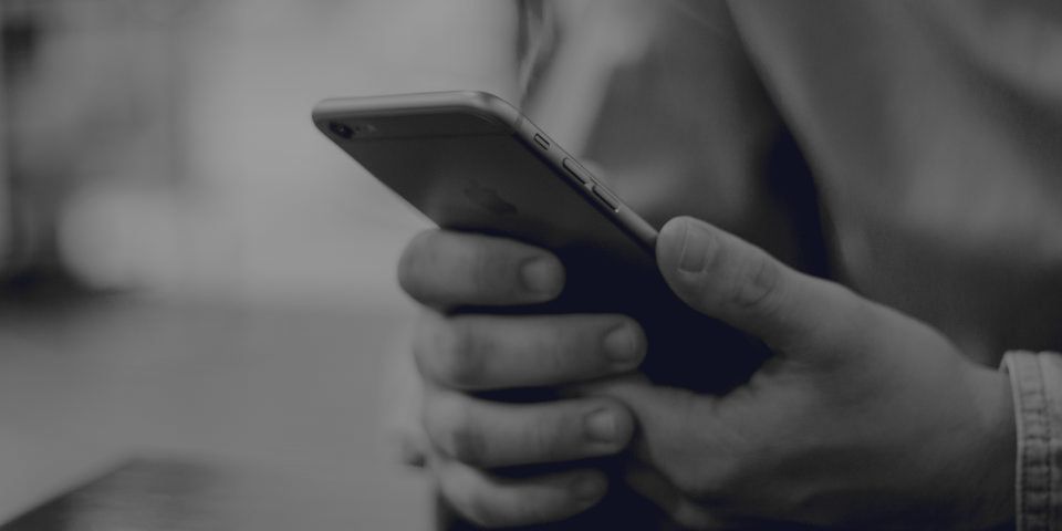A person holding their mobile phone in both hands.