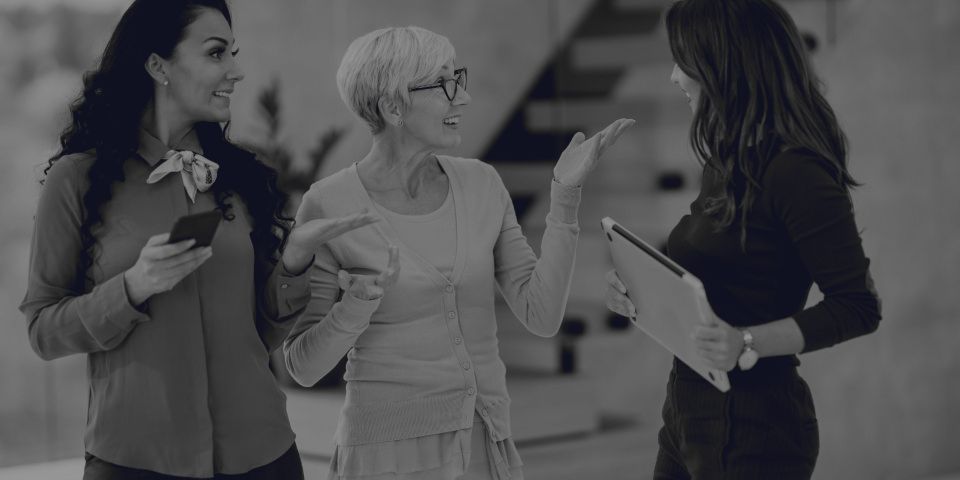 Three people talking, one of them explaining something with their hands.