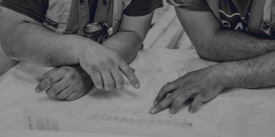 A person pointing at a spot on a diagram while the others listen.